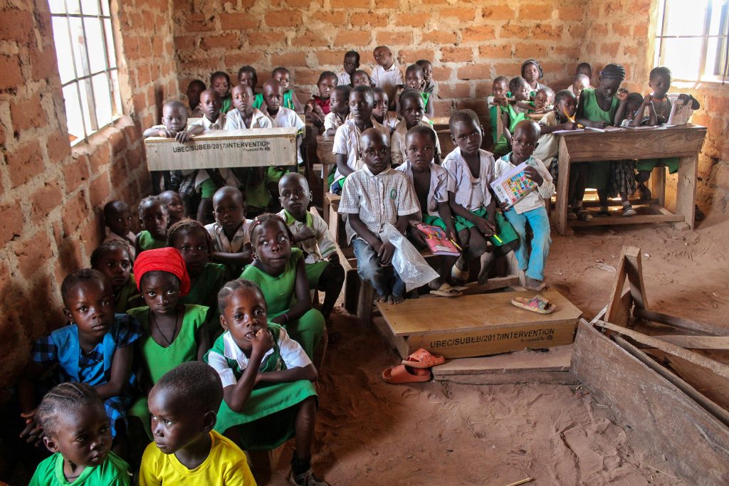 Barriers to Accessing Quality Education among Refugees in Uganda: Institutional, Economic, and Sociocultural Perspectives A group of children in a rustic classroom environment eager to learn.